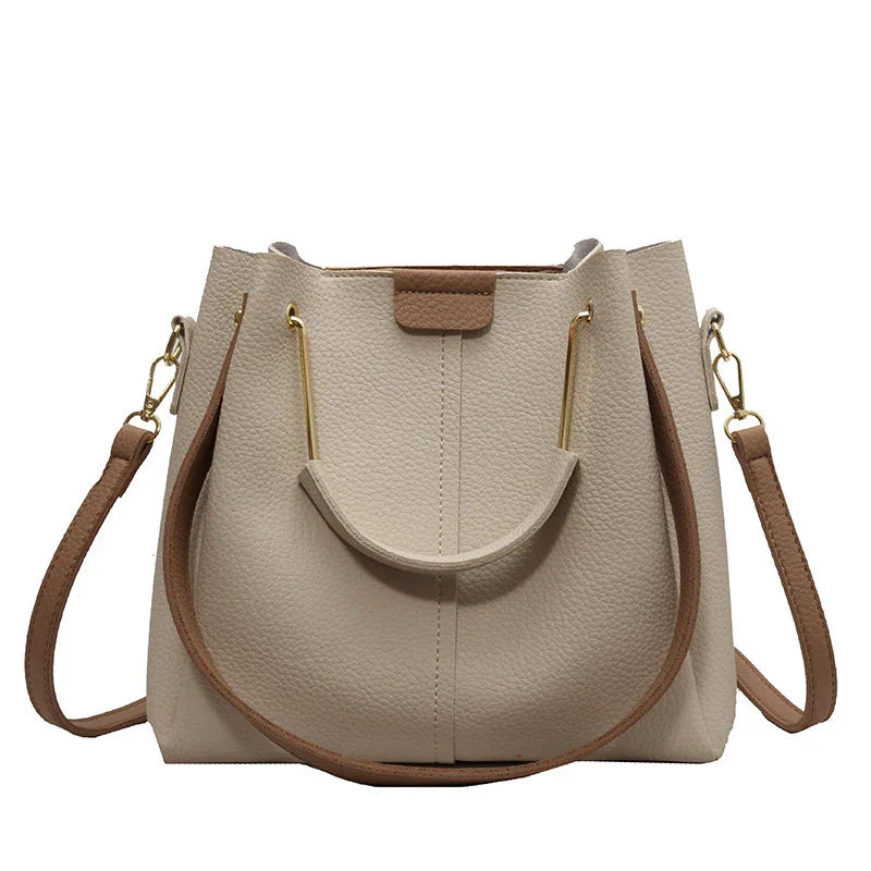 Beige textured leather handbag with brown straps and gold-tone hardware, modern tote style