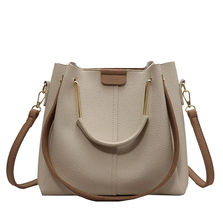 Beige textured leather handbag with brown straps and gold-tone hardware, modern tote style
