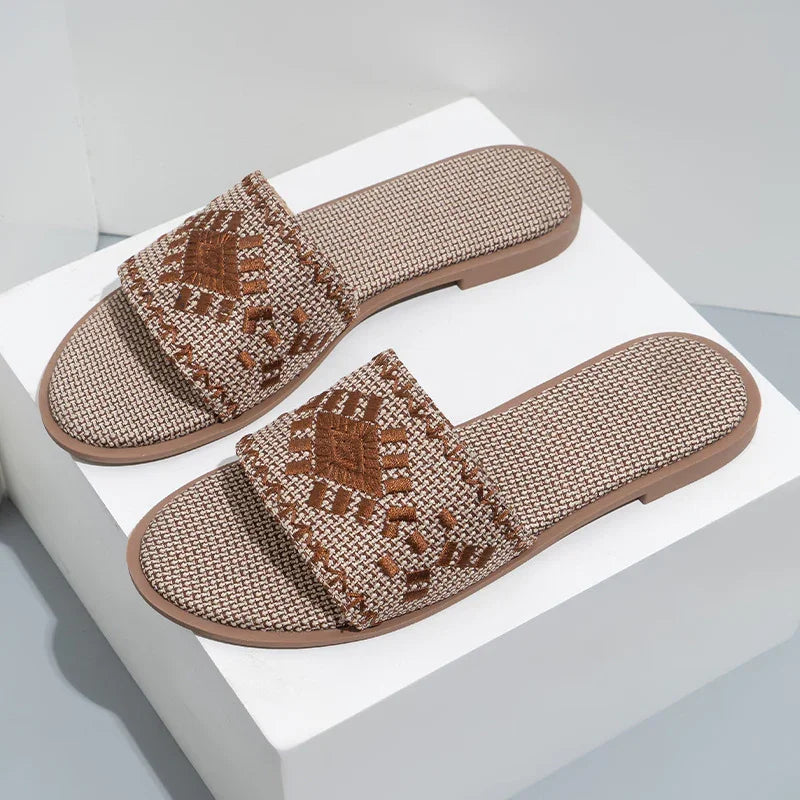 Brown and beige woven slide sandals with geometric embroidered design on strap