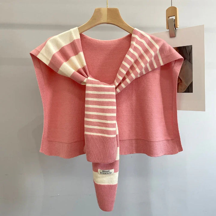 Pink sleeveless sweater with a pink and white striped scarf draped over shoulders on wooden hanger