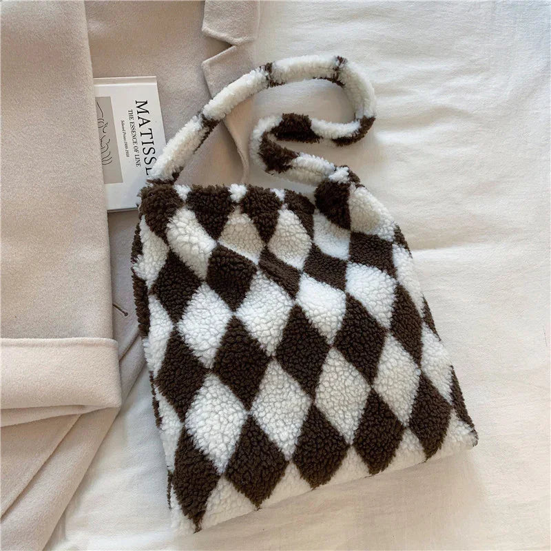 Cozy brown and white checkered fleece handbag with soft texture on beige fabric background