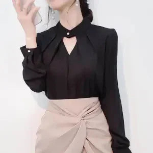 Woman wearing a black long-sleeve blouse with a keyhole neckline and beige high-waist skirt with knot detail