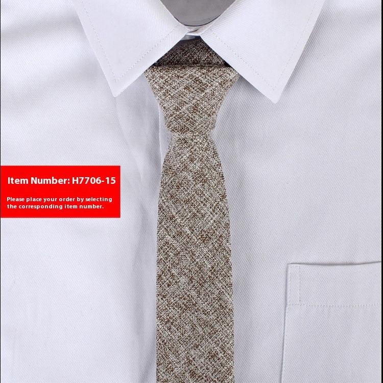 Close-up of textured brown and beige tie on white dress shirt with a pointed collar and pocket