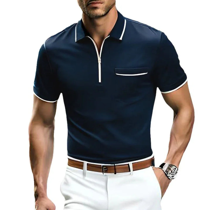 Man wearing navy blue slim fit polo shirt with white trim and white pants, brown belt, wristwatch