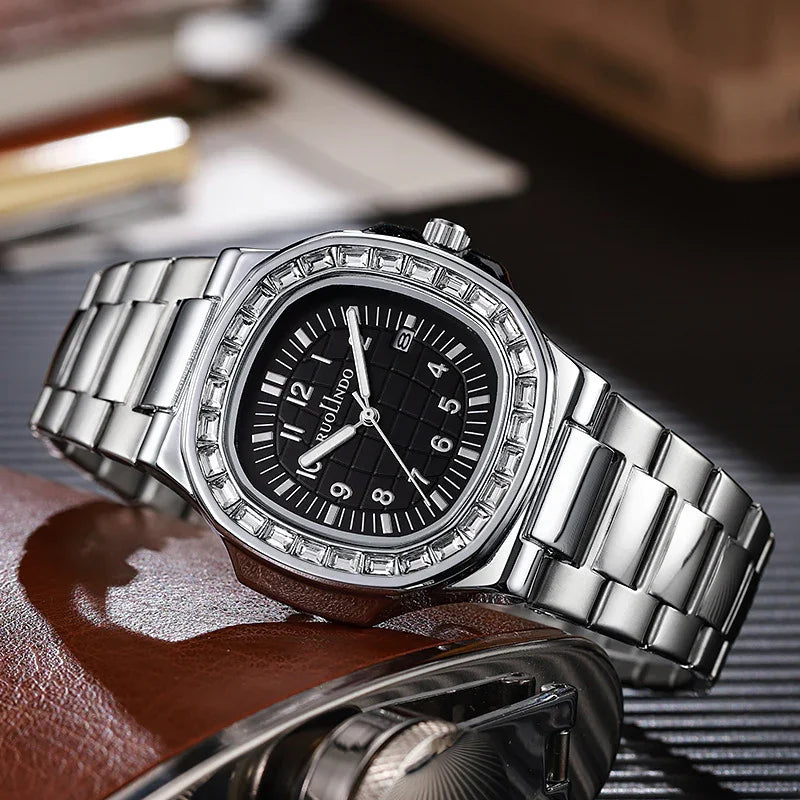 Silver stainless steel wristwatch with black dial and crystal bezel on leather and metal surface