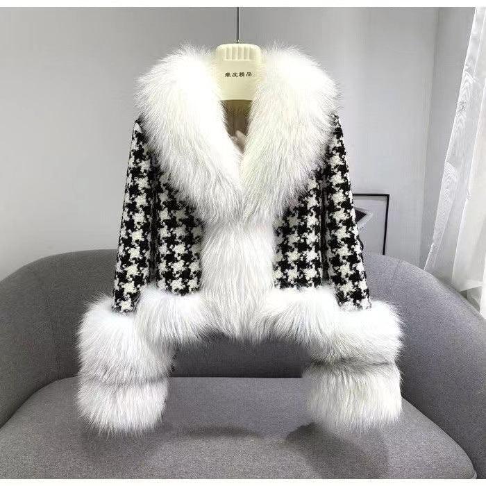 Black and white houndstooth jacket with large white faux fur collar and cuffs on gray sofa
