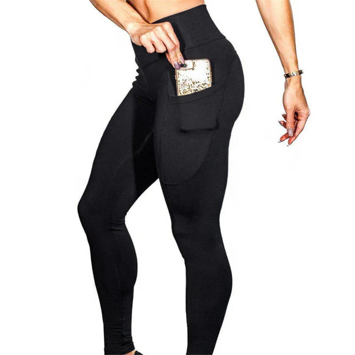 Woman wearing high-waist black leggings with side pocket holding a gold glitter phone