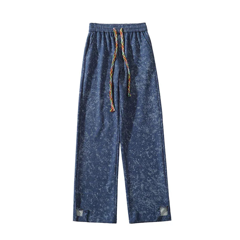 Blue textured sweatpants with multicolor braided drawstring and reflective patches near hems