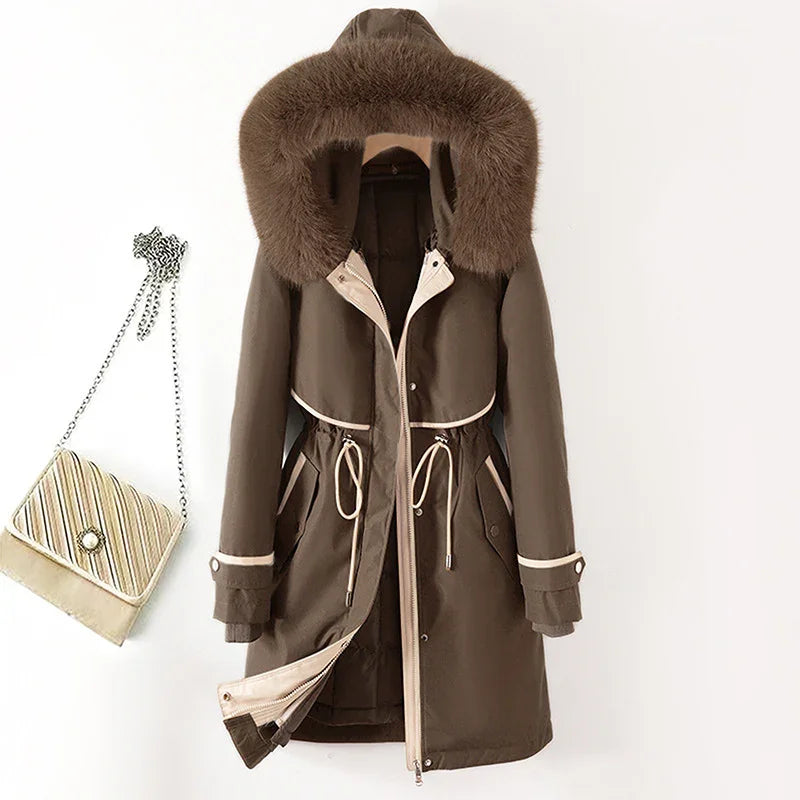 brown winter parka with fur hood, drawstring waist, and beige trim hanging next to striped chain purse