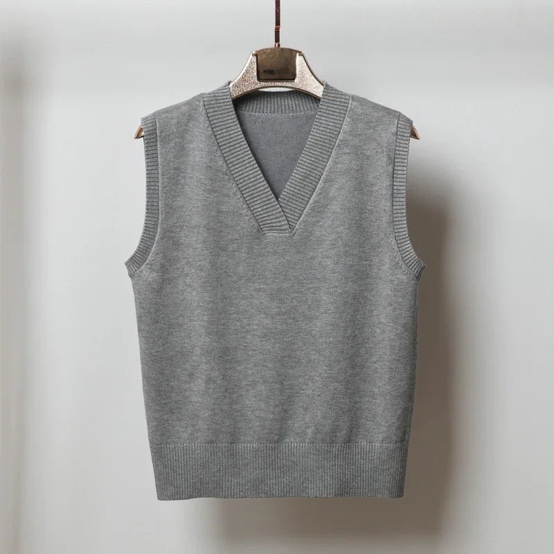 Gray sleeveless V-neck knit sweater vest hanging on wooden hanger against white background
