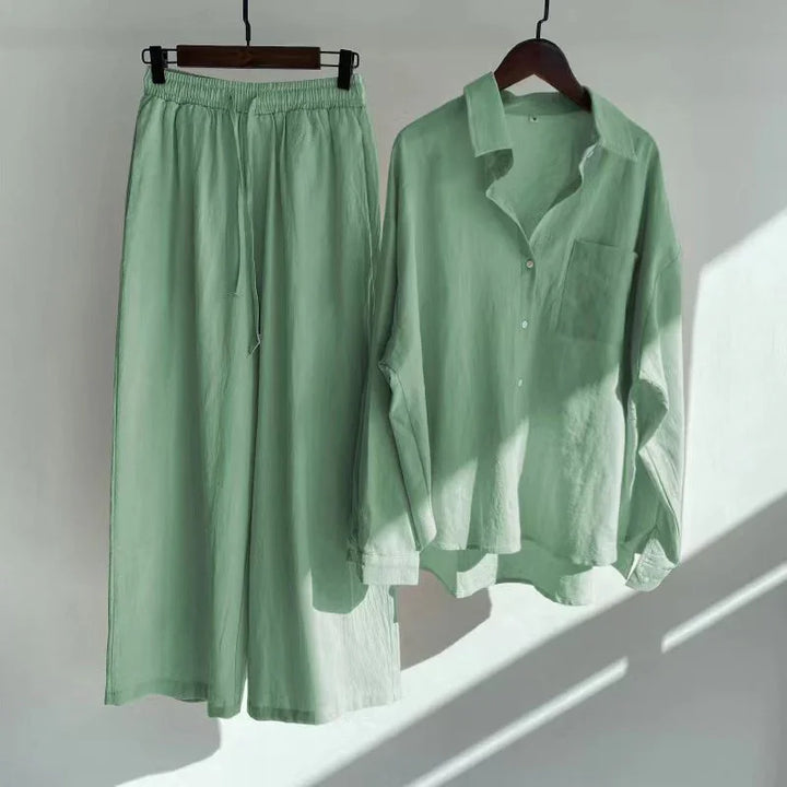 Light green loose linen pants with elastic waist and matching button-up shirt on hangers