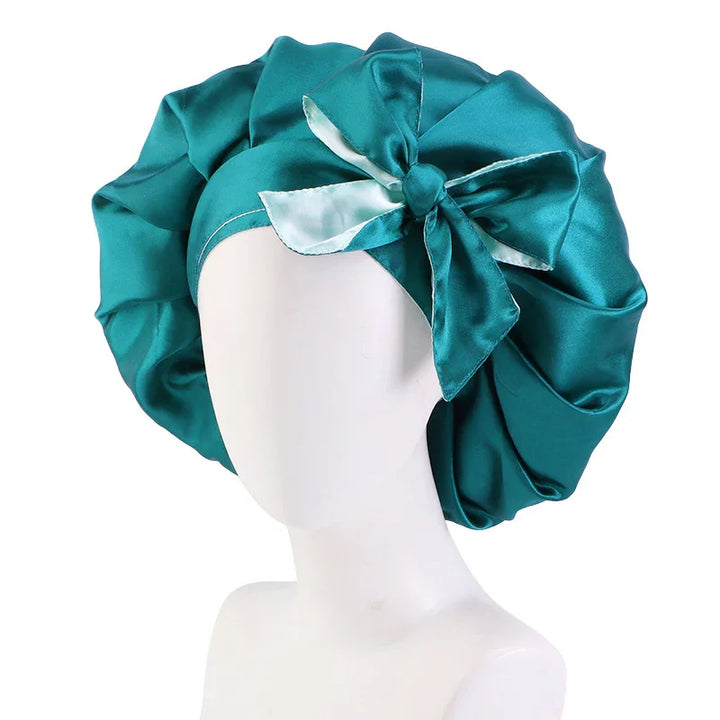 Teal satin bonnet with white satin bow on a white mannequin head