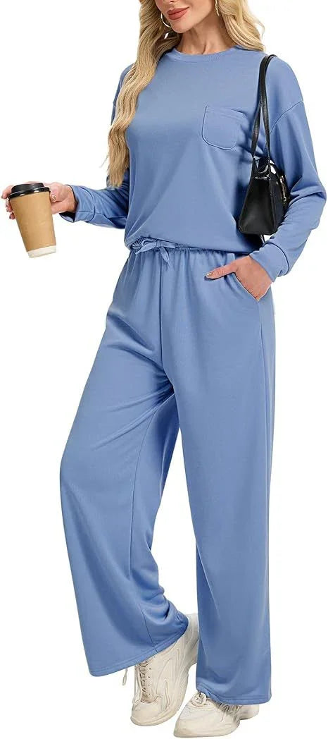 Woman wearing comfortable blue lounge set with long sleeves and wide-leg pants holding coffee cup and black handbag