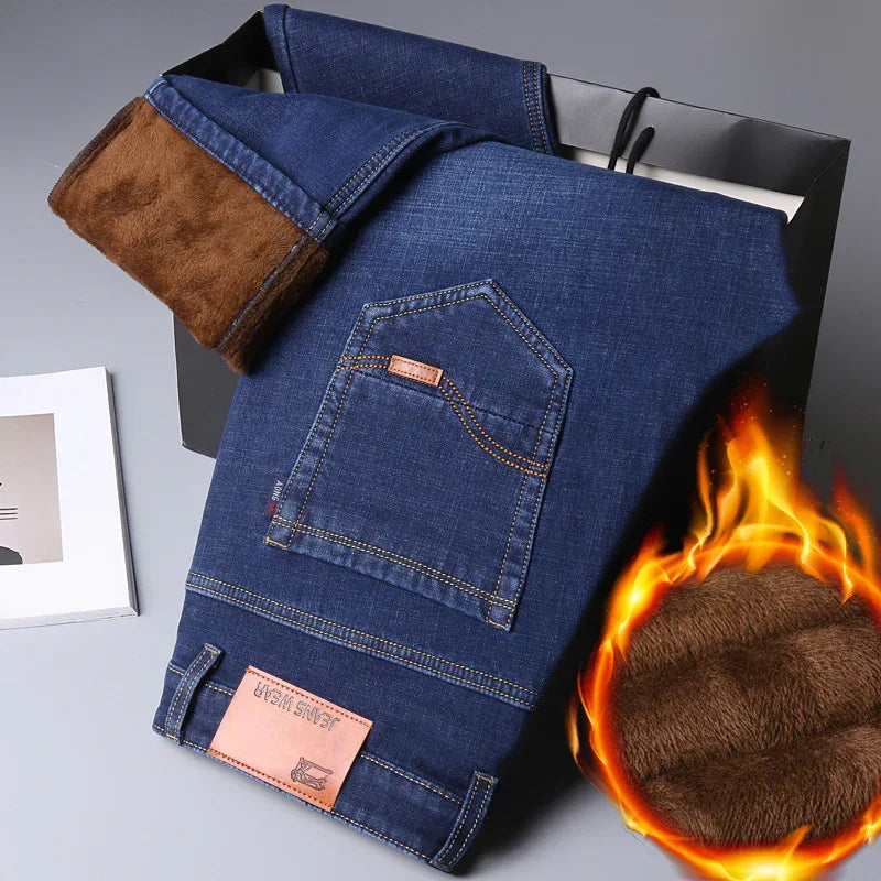 Folded blue jeans with brown fleece lining, displayed on black shopping bag, warm winter denim