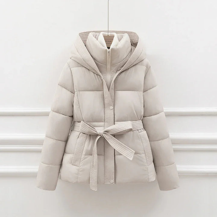 Light beige padded winter jacket with hood, zipper, snap buttons, and fabric belt tied at waist