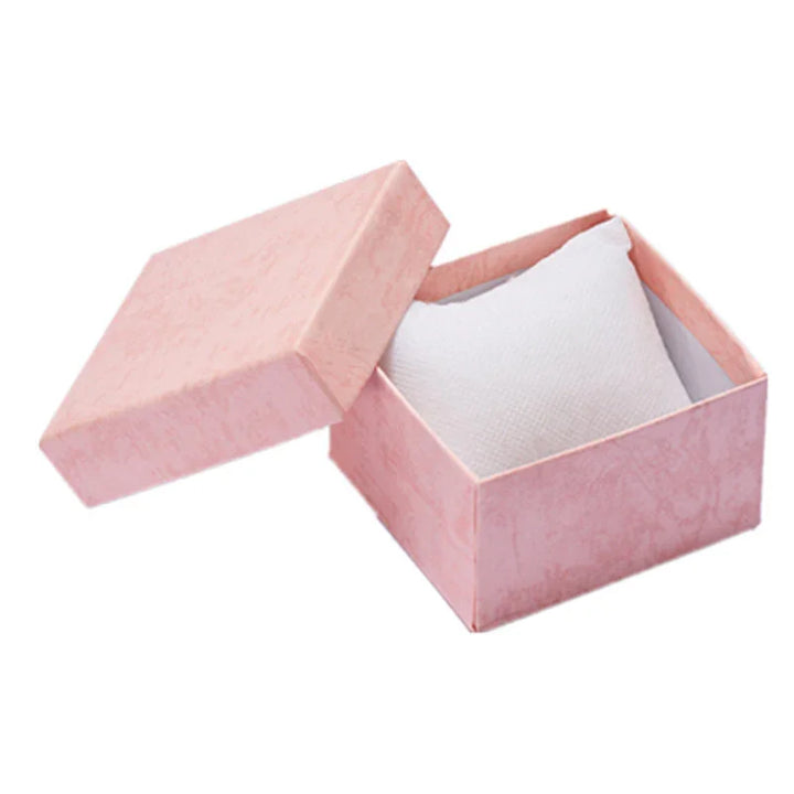 Pink square gift box with removable lid and white cushion inside on white background