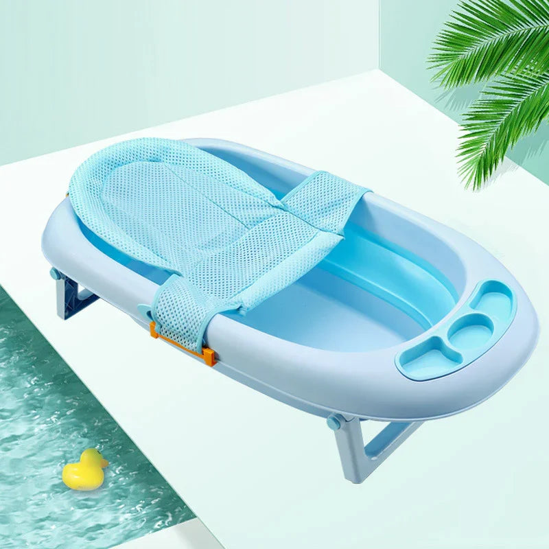 Light blue baby bathtub with mesh sling and built-in compartments on white surface near pool and green palm leaves