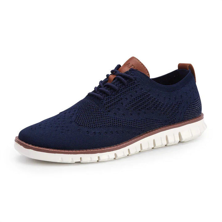 Navy blue knitted men's casual sneaker with white flexible sole and brown leather accents
