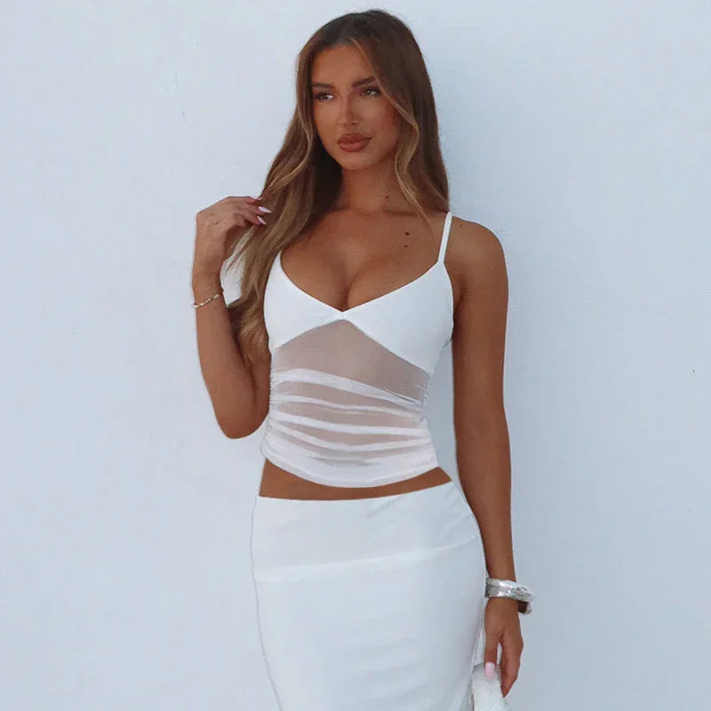 woman in white mesh panel sleeveless top and matching white skirt against plain background