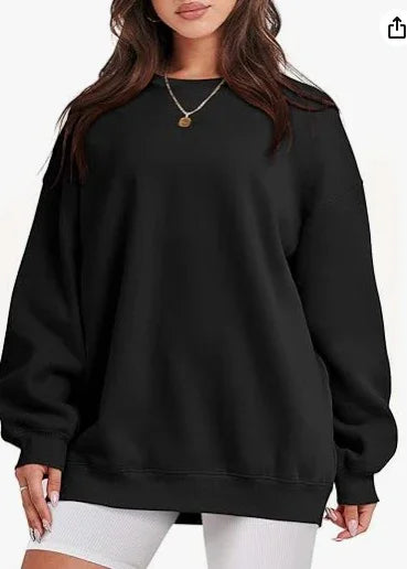 Woman wearing oversized black sweatshirt with long sleeves and white shorts, casual fashion
