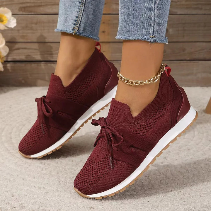 Womens burgundy knit sneakers with laces, white sole, worn with cropped jeans and gold anklet