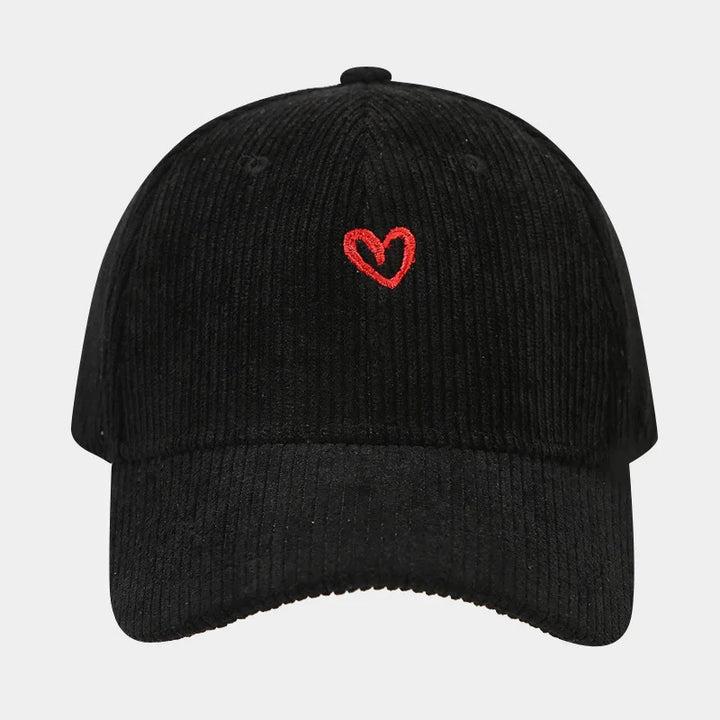 Black ribbed corduroy baseball cap with small red embroidered heart on front