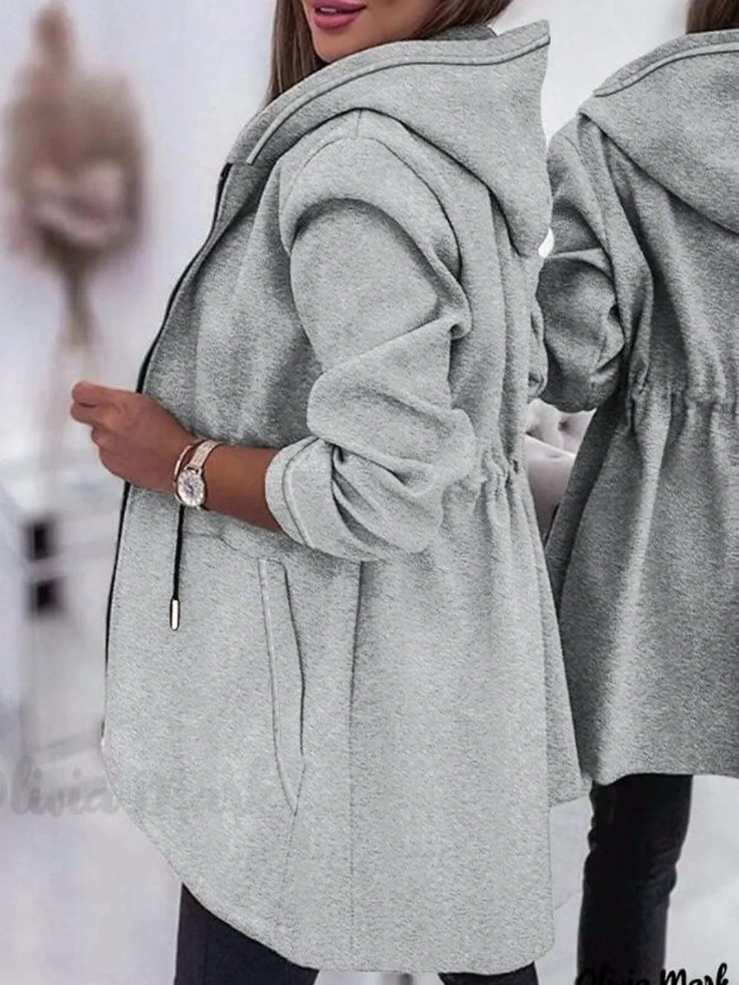 woman wearing light gray hooded jacket with rolled-up sleeves and zipper detail