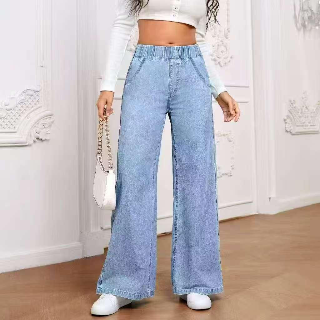 woman wearing light blue wide-leg high-waisted jeans with elastic waistband and white sneakers
