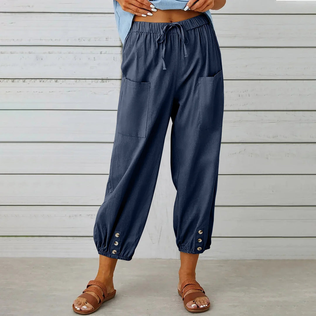 Women’s navy blue casual drawstring pants with front pockets and button cuffs styled with brown sandals