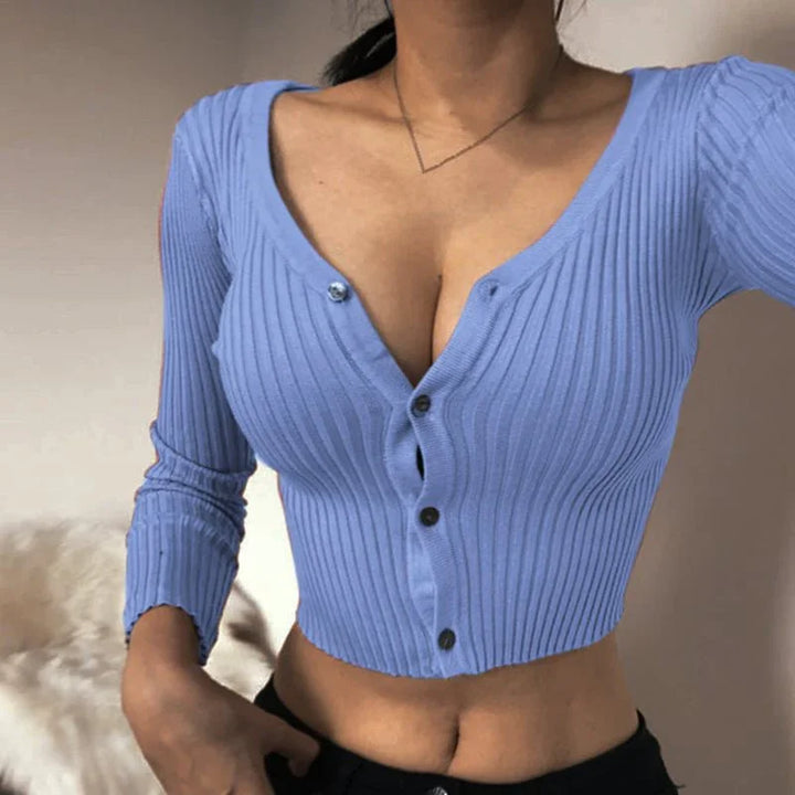 Woman wearing a fitted ribbed blue cropped cardigan with buttons and a V-neckline
