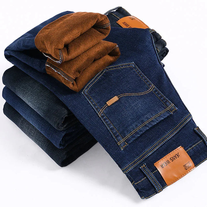 Stack of folded dark blue denim jeans with brown fleece lining and leather patches