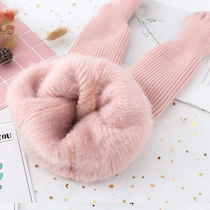 Soft pink fuzzy wool knit scarf with ribbed ends, styled on white star-patterned surface