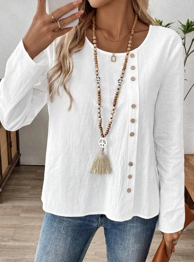 Woman wearing white long-sleeve buttoned top and peace sign wooden bead necklace