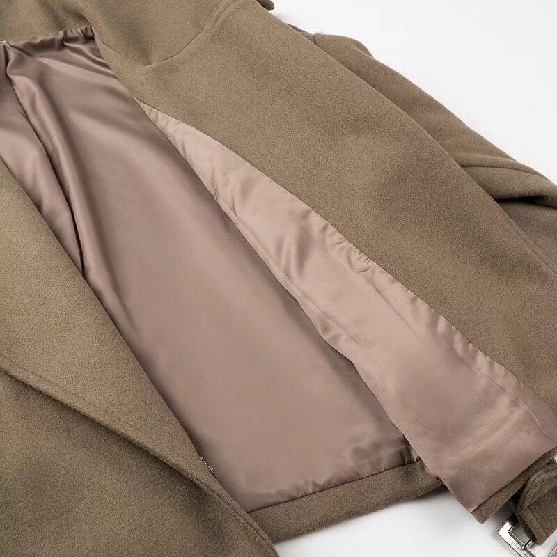 Close-up of camel brown wool coat with smooth beige satin lining and silver buckle detail