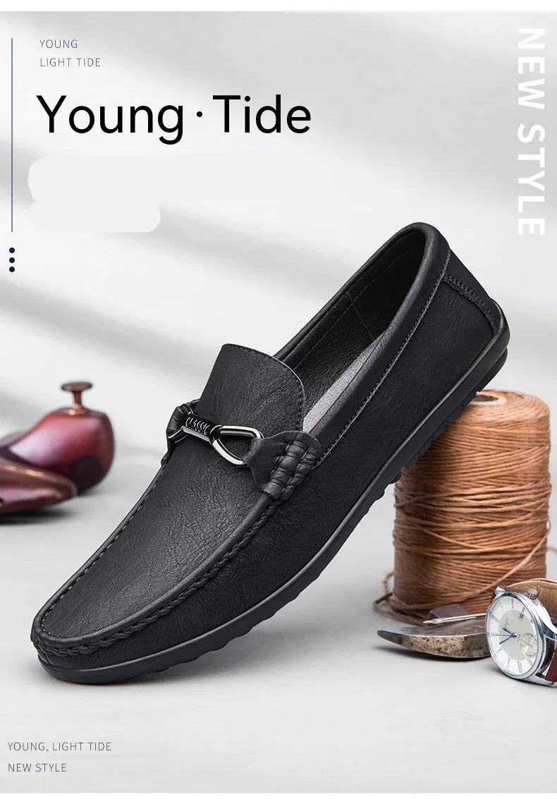 Black leather slip-on loafer with metal buckle detail, displayed with watch and sewing thread spool
