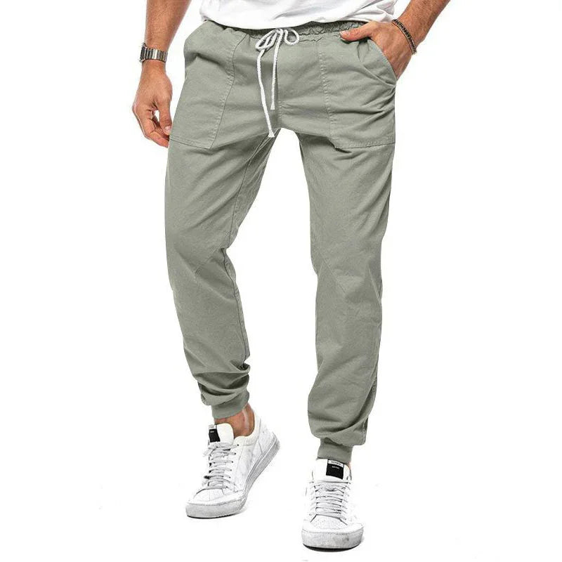 men's light gray casual jogger pants with drawstring waist and ankle cuffs, paired with white sneakers