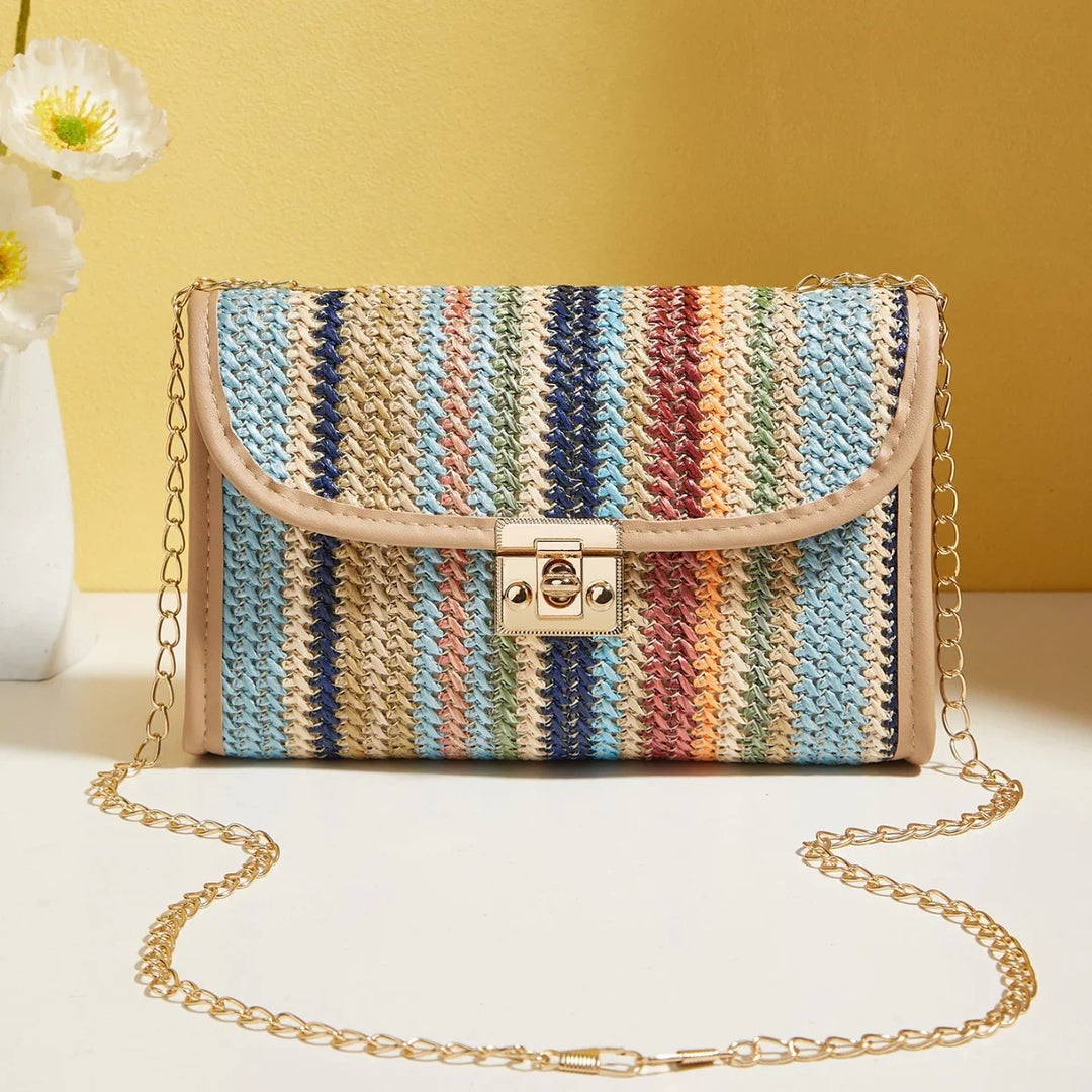 Colorful woven crossbody bag with gold chain strap and clasp on white surface