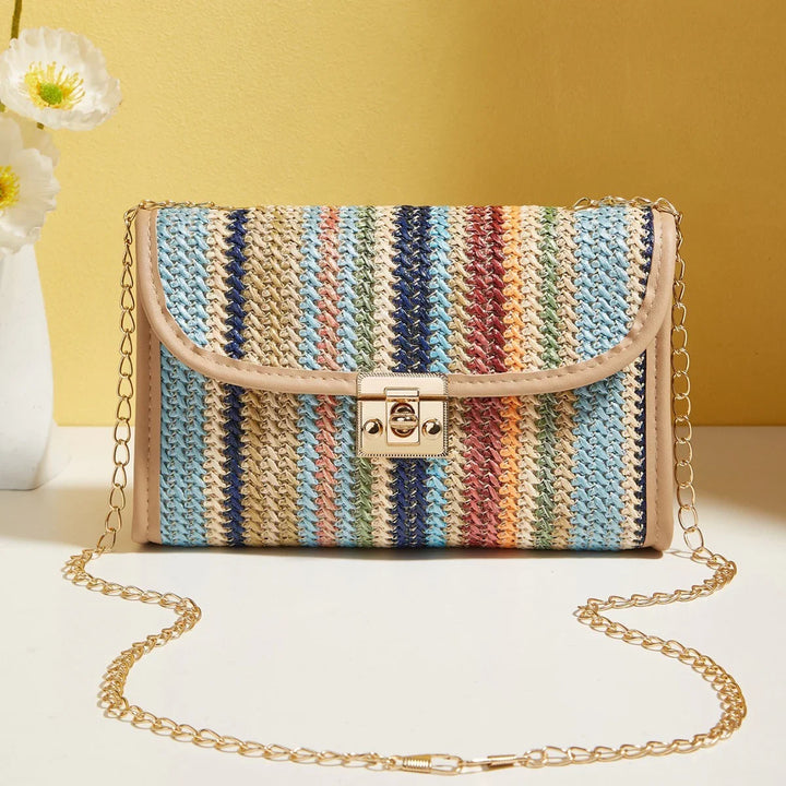 Colorful woven crossbody bag with gold chain strap and clasp on white surface