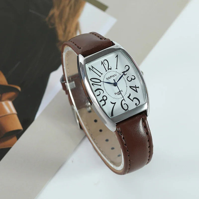 Brown leather strap wristwatch with silver rectangular case and white dial featuring large black stylized numbers