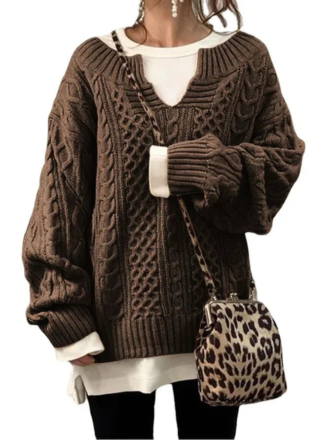 Woman wearing brown cable knit sweater with white layered top and leopard print crossbody bag
