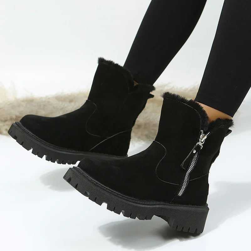 Black suede winter ankle boots with fur lining and side zipper on a model wearing black leggings