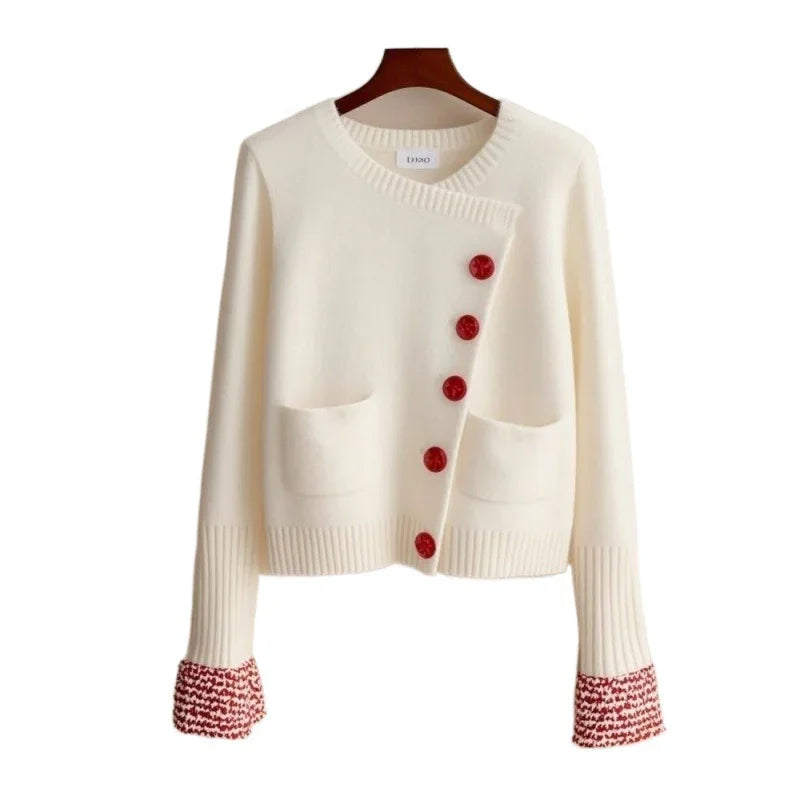White knitted cardigan with red buttons and red patterned cuffs, featuring two front pockets
