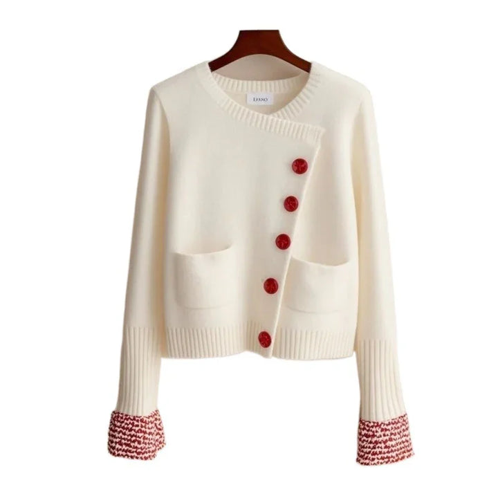 White knitted cardigan with red buttons and red patterned cuffs, featuring two front pockets
