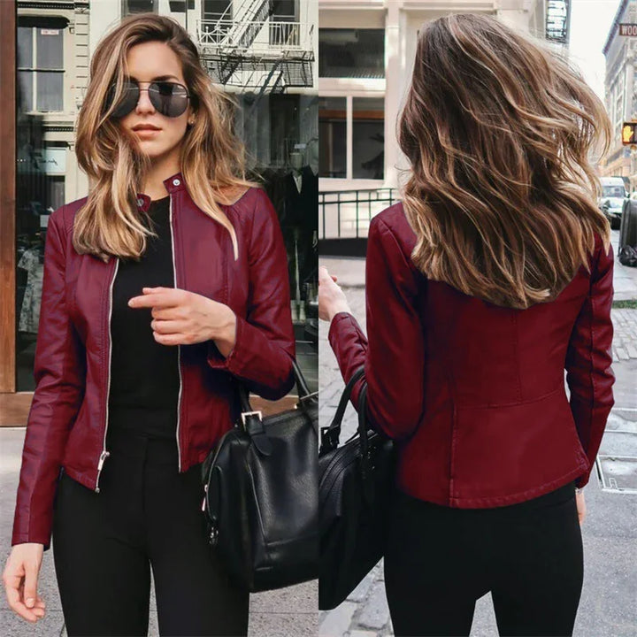 Stylish woman wearing a red leather jacket and black pants holding a black handbag in an urban street setting