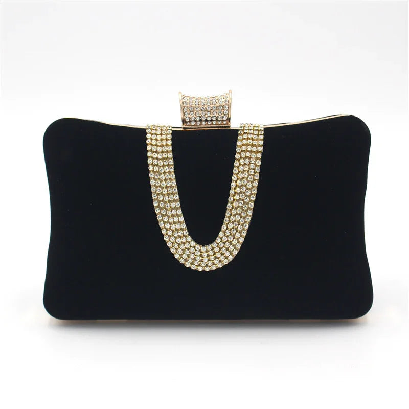 Elegant black velvet clutch bag with a gold and rhinestone chain strap and rhinestone clasp