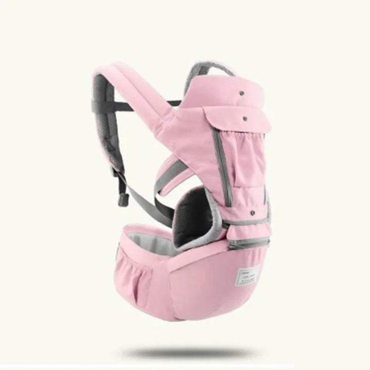Pink ergonomic baby carrier with padded straps and storage pockets on a white background