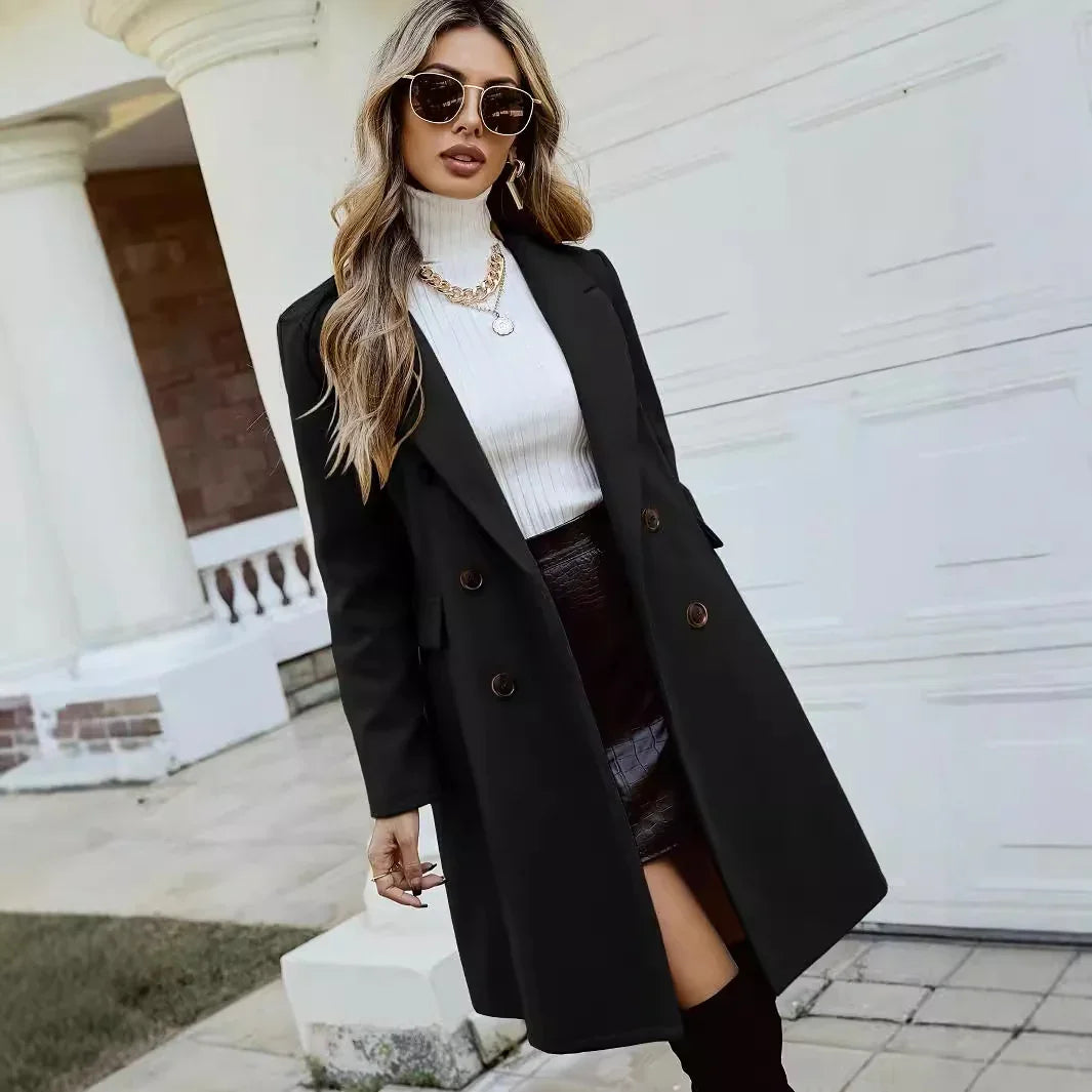 Woman wearing black double-breasted coat, white turtleneck sweater, black skirt, and round sunglasses outdoors