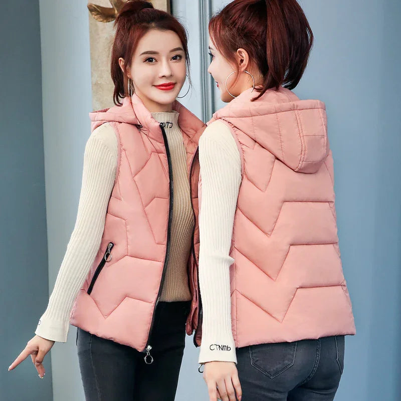 Woman wearing a pink quilted hooded vest over beige ribbed sweater and dark jeans, shown front and back