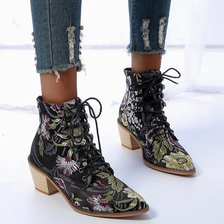 Black floral lace-up ankle boots with wooden block heels worn with distressed denim jeans