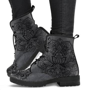 Black leather ankle boots with intricate floral mandala patterns worn with black leggings